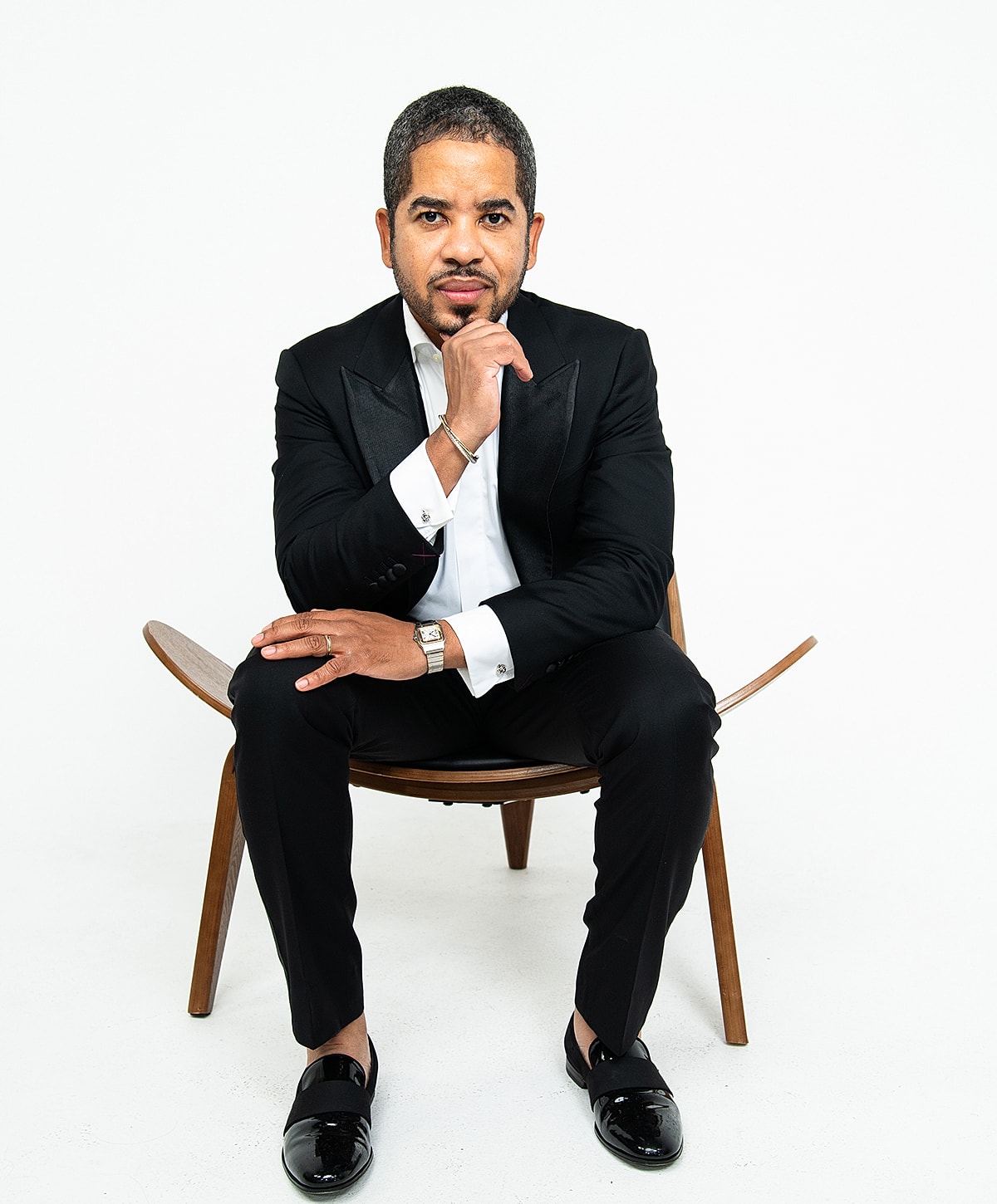 Man in formal attire sitting on chair.