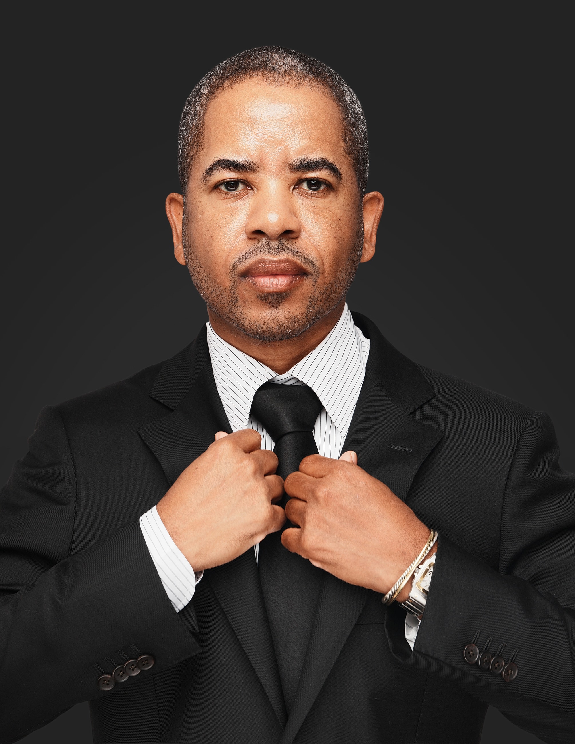 Man adjusting his tie in a suit.