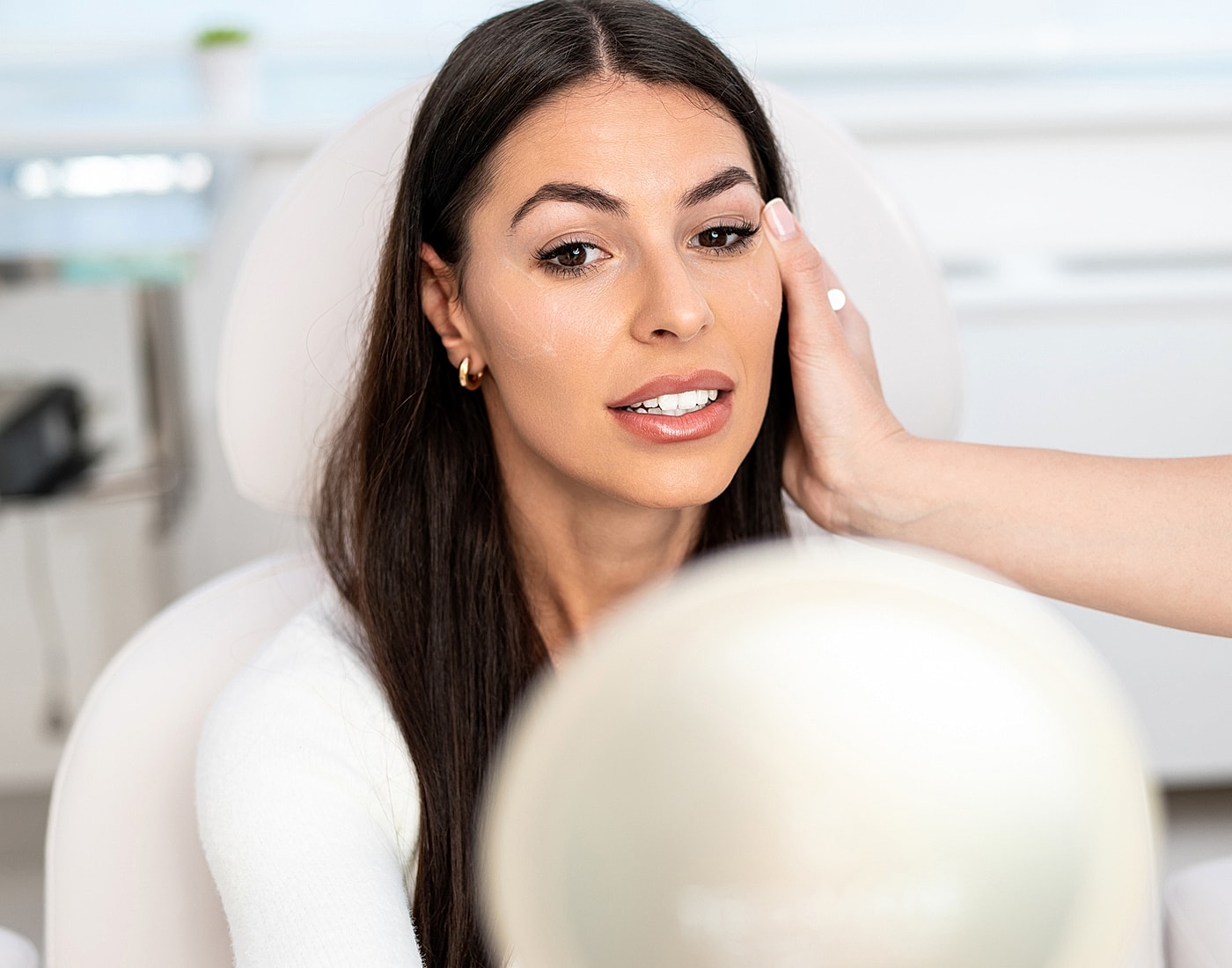 Woman getting makeup applied in beauty salon.